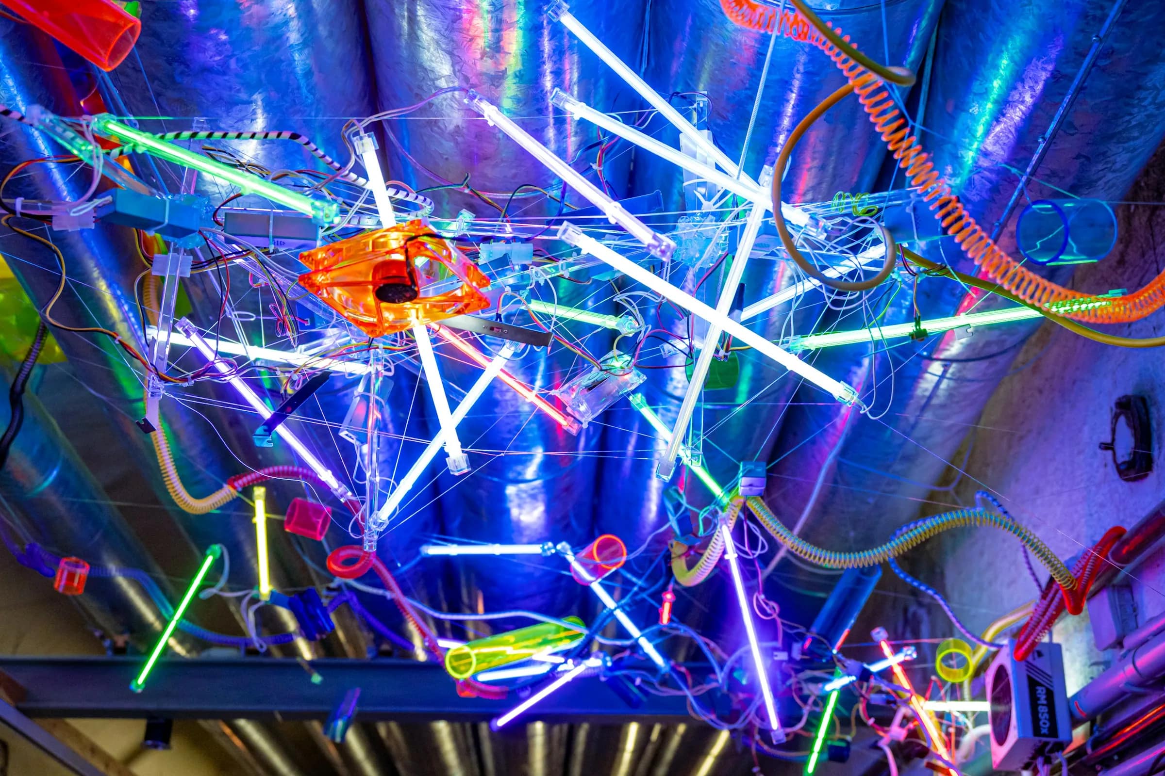 Neon tubes and exposed wiring rigged across a dark interior