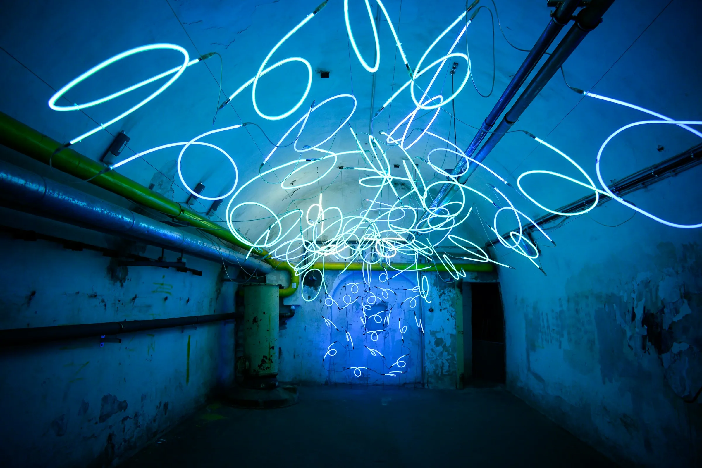 Abstract blue light installation stretching down a dark tunnel